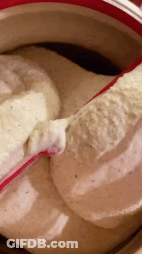 A Close Up Of A Bowl Of Ice Cream With A Red Spoon In It GIF
