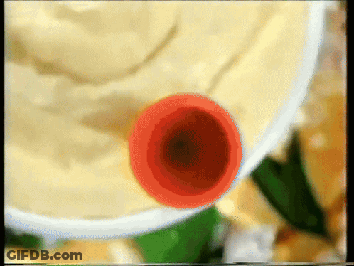 A Close Up Of A Bowl Of Mashed Potatoes With A Red Object In It GIF