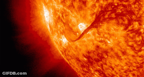 A Close Up Of A Bright Orange Sun With A Dark Background GIF