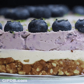 A Close Up Of A Cake With Blueberries On Top Of It GIF