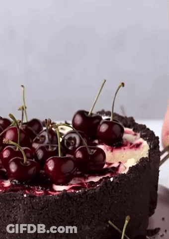 A Close Up Of A Cake With Cherries On Top Of It GIF