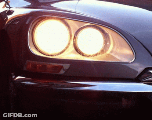 A Close Up Of A Car 'S Headlights That Are Lit Up GIF