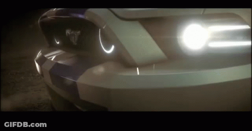 A Close Up Of A Car 'S Headlights With The Word Mustang On The Front GIF