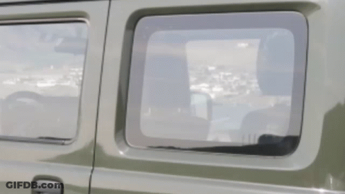 A Close Up Of A Car Window With A Reflection Of A City GIF