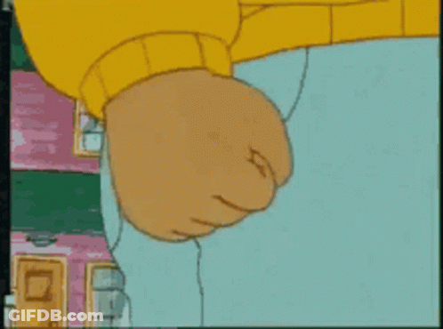 A Close Up Of A Cartoon Character 'S Fist With A Pink Building In The Background GIF