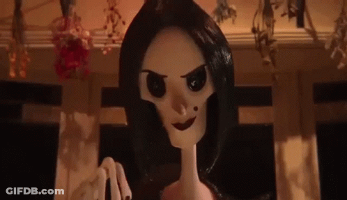 A Close Up Of A Cartoon Doll With Black Hair And A Skeleton Head . GIF