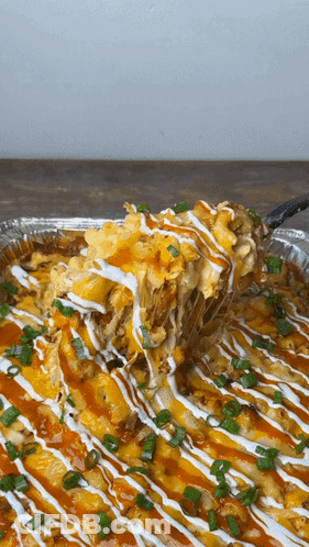 A Close Up Of A Casserole Dish With A Spoon Taking A Bite Out Of It GIF