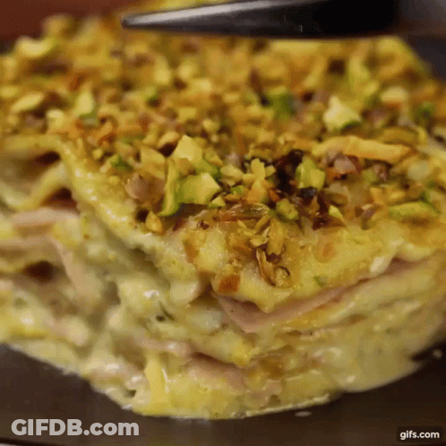 A Close Up Of A Casserole Dish With Pistachios On Top Of It GIF