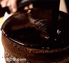 A Close Up Of A Chocolate Cake Being Covered In Chocolate GIF