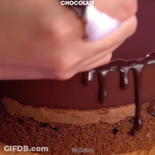 A Close Up Of A Chocolate Cake Being Decorated GIF