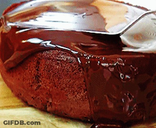 A Close Up Of A Chocolate Cake With A Spoon Sticking Out Of It GIF