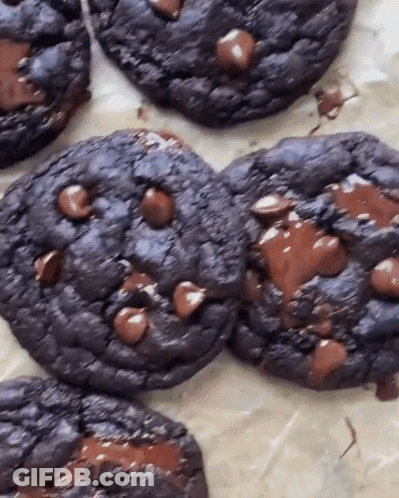 A Close Up Of A Chocolate Chip Cookie On A Table GIF