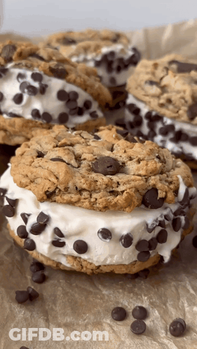 A Close Up Of A Chocolate Chip Cookie Sandwich On A Table GIF