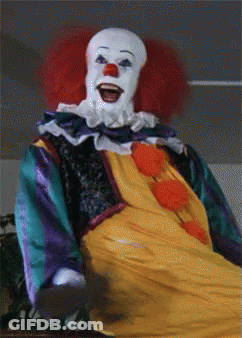 A Close Up Of A Clown With Red Hair And White Face GIF