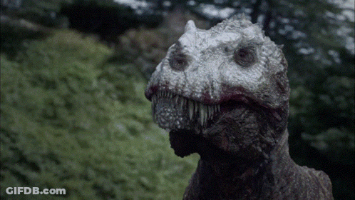 A Close Up Of A Dinosaur 'S Face With A Blurred Background GIF