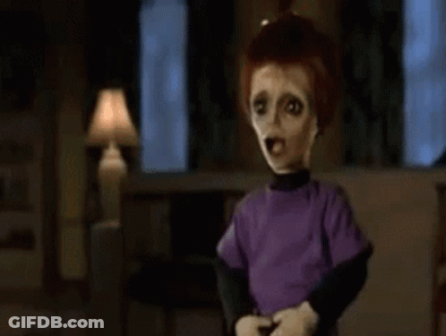 A Close Up Of A Doll 'S Face In A Dark Room With A Blurred Background . GIF