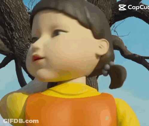 A Close Up Of A Doll 'S Face With A Tree In The Background . GIF