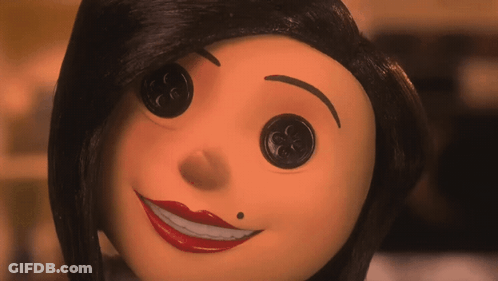 A Close Up Of A Doll 'S Face With Buttons In Her Eyes GIF