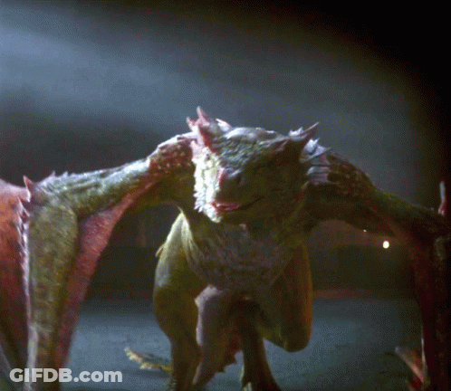 A Close Up Of A Dragon 'S Face And Wings In The Dark GIF