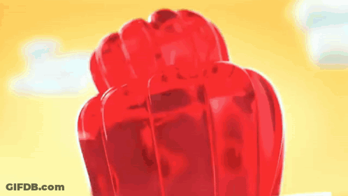 A Close Up Of A Fist Made Out Of Jelly On A Yellow Background . GIF