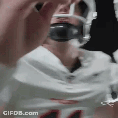 A Close Up Of A Football Player Wearing A Helmet And Headphones . GIF