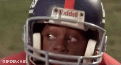 A Close Up Of A Football Player Wearing A Helmet And Looking At The Camera . GIF