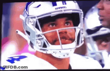 A Close Up Of A Football Player Wearing A Helmet And Looking At The Camera . GIF