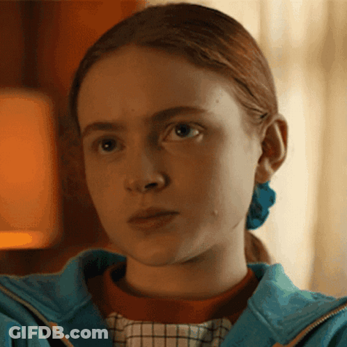 A Close Up Of A Girl 'S Face Wearing A Blue Jacket GIF