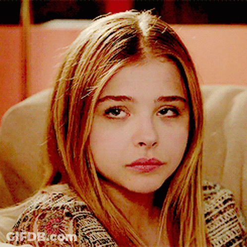 A Close Up Of A Girl 'S Face With A Floral Shirt On GIF
