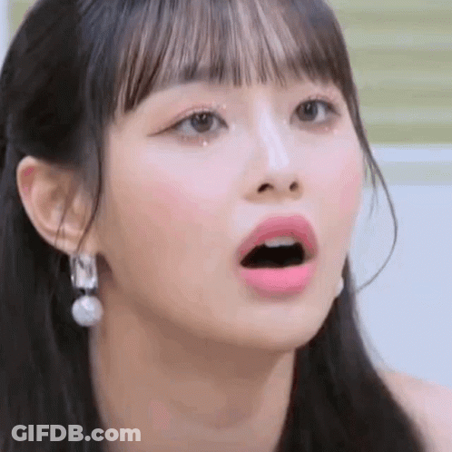 A Close Up Of A Girl 'S Face With Her Mouth Open And Earrings . GIF