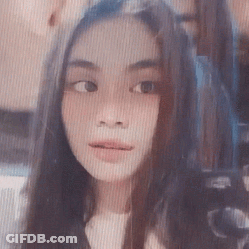 A Close Up Of A Girl 'S Face With Long Hair And A Striped Background . GIF