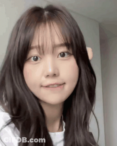 A Close Up Of A Girl 'S Face With Long Hair And Bangs . GIF