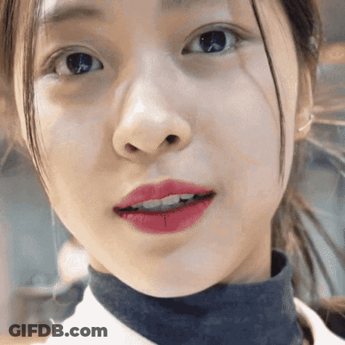 A Close Up Of A Girl 'S Face With Red Lipstick On Her Lips GIF
