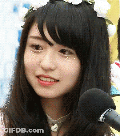 A Close Up Of A Girl Wearing A Flower Crown And A Microphone GIF