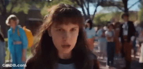 A Close Up Of A Girl With Long Hair Standing In Front Of A Crowd . GIF