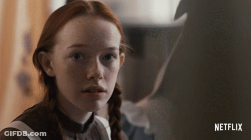 A Close Up Of A Girl With Red Hair And A Netflix Logo In The Background GIF