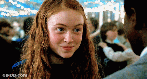 A Close Up Of A Girl With Red Hair Looking At A Man GIF