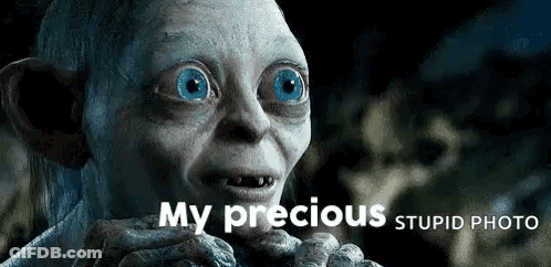 A Close Up Of A Gollum With Blue Eyes And The Words `` My Precious Stupid Photo '' Above Him . GIF
