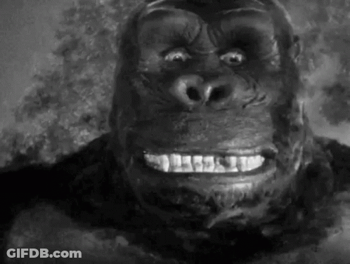A Close Up Of A Gorilla 'S Face With A Smile On It 'S Face In A Black And White Photo . GIF