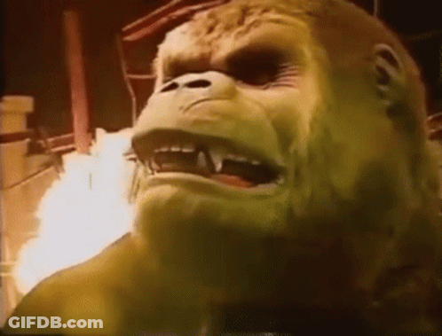 A Close Up Of A Gorilla 'S Face With Fire Coming Out Of It 'S Mouth . GIF