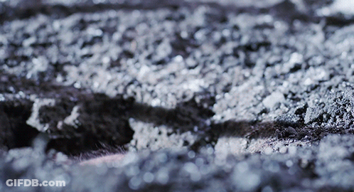 A Close Up Of A Gray Surface With A Few White Spots GIF