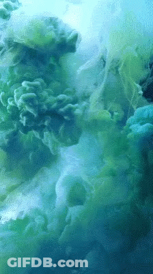 A Close Up Of A Green And Blue Smoke Coming Out Of The Water GIF