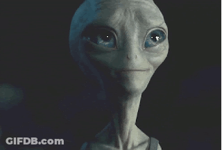 A Close Up Of A Grey Alien 'S Face With Blue Eyes GIF