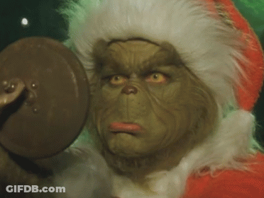 A Close Up Of A Grinch 'S Face With A Santa Hat On GIF