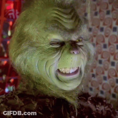 A Close Up Of A Grinch 'S Face With A Very Angry Expression . GIF