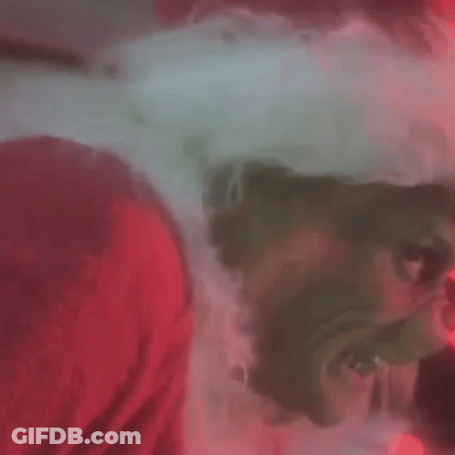 A Close Up Of A Grinch 'S Face With Glowing Red Eyes GIF