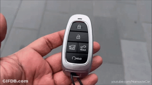 A Close Up Of A Hand Holding A Car Key With The Word Hold On It GIF