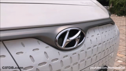 A Close Up Of A Hyundai Logo On The Front Of A White Car GIF