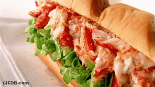 A Close Up Of A Lobster Sandwich On A Bun With Lettuce GIF