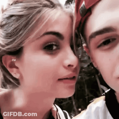 A Close Up Of A Man And A Woman 'S Faces With The Letters Em On The Bottom Right GIF